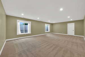 Unfurnished room featuring light carpet, plenty of natural light, and recessed lighting
