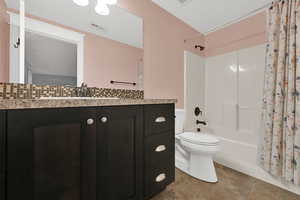 Bathroom featuring shower / bath combination with curtain, vanity, light tile patterned flooring, and backsplash