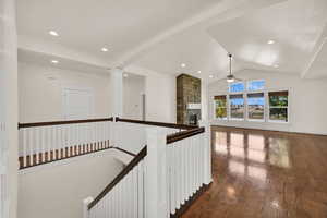 Hall with dark wood finished floors, high vaulted ceiling, and recessed lighting