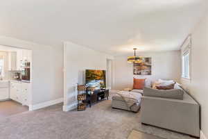 Living room featuring light colored carpet and a chandelier