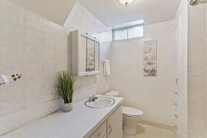 Bathroom with vanity, tile patterned flooring, and tile walls