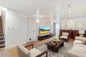 Living area with stairway and baseboards