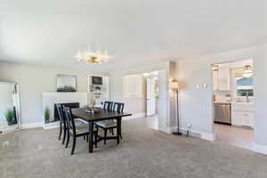 Dining space featuring light colored carpet and a fireplace