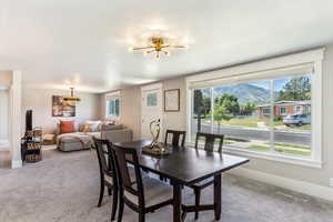 Dining space featuring a chandelier, carpet, healthy amount of natural light, and a mountain view
