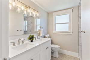 Full bath featuring double vanity and plenty of natural light