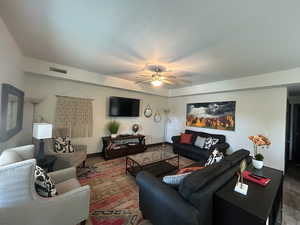 Living room with a ceiling fan and baseboards