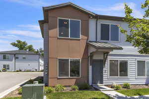 View of front of property with a standing seam roof, a metal roof, and stucco siding