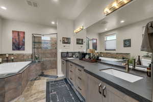 Bathroom featuring double vanity, a stall shower, a garden tub, and recessed lighting
