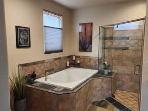 Bathroom featuring a bath and a shower stall