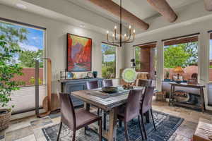 Dining space with stone tile flooring, beamed ceiling, a chandelier, and recessed lighting