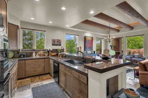 Kitchen with stone tile flooring, tile countertops, recessed lighting, a peninsula, and dishwasher