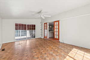 Spare room with ceiling fan, french doors, and vaulted ceiling