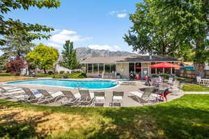 Community pool, patio and clubhouse featuring a mountain view