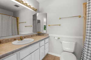Bathroom featuring vanity, light tile patterned floors, and a shower with shower curtain