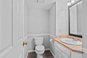 Half bath with vanity and dark wood-style flooring
