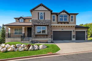 View of front of house featuring stone siding, stucco siding, concrete driveway, a garage, and a front yard