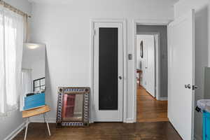 Hallway with dark wood-style floors and baseboards
