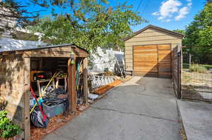 View of shed featuring concrete driveway