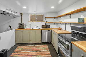 Kitchen featuring open shelves, stainless steel appliances, recessed lighting, and wooden counters