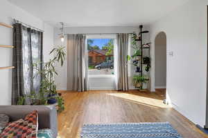 Living area with light wood-style floors and arched walkways