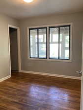 Spare room with plenty of natural light and dark wood finished floors