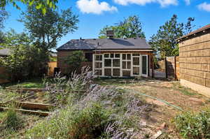 Back of house with a sunroom, a garden, a fenced backyard, and a shingled roof