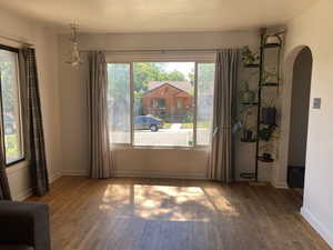 Spare room featuring arched walkways and hardwood / wood-style floors
