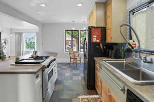 Kitchen featuring high end stainless steel range oven, decorative light fixtures, stone finish flooring, a kitchen island, and recessed lighting