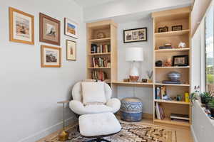 Sitting room featuring wood finished floors and built in features
