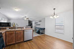 Bright and functional layout with laminate wood flooring, ample cabinet space, and a bar-height counter perfect for casual dining or entertaining. The adjoining dining area enjoys natural light and modern lighting.