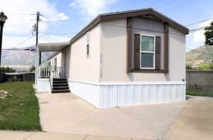 Another view of the home’s welcoming exterior, showcasing updated siding and a neat yard with room to garden or relax outdoors.