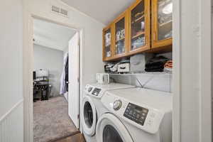 Separate laundry space with full-size washer and dryer included, built-in shelving, and upper cabinets for tons of extra storage. Conveniently located near the primary bedroom.
