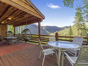 Wooden terrace with outdoor dining area and a mountain view