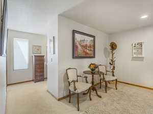 Sitting room with light colored carpet and recessed lighting