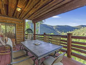 Wooden deck with a mountain view and outdoor dining area