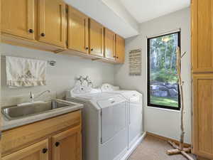Laundry area featuring washer and dryer, cabinet space, and light colored carpet