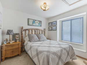 Bedroom with light carpet and baseboards
