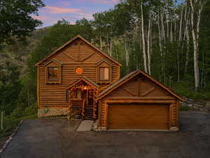 Log-style house featuring log exterior and a view of trees