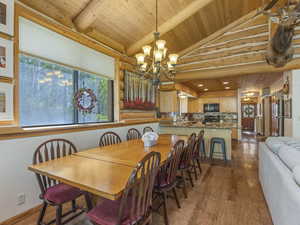 Dining room with wood ceiling, wood-type flooring, and a chandelier