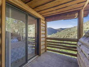 Doorway with a mountain view, brick flooring, and wood ceiling