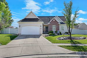 Traditional-style home featuring an attached garage, concrete driveway, and a shingled roof