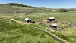 Overview of rural landscape featuring a pastoral area and a mountain backdrop