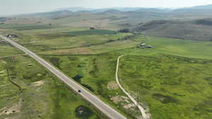 Aerial view of property and surrounding area featuring rural landscape and a mountainous background