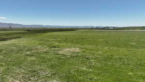 View of green lawn featuring a view of rural / pastoral area and a mountain view