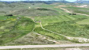 Aerial view of property and surrounding area featuring mountains and rural landscape