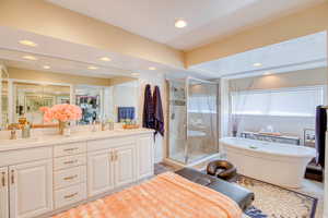 Full bath with recessed lighting, double vanity, a shower stall, and a freestanding tub
