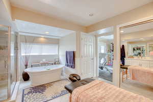 Bathroom featuring a shower stall, a freestanding tub, vanity, wainscoting, and recessed lighting
