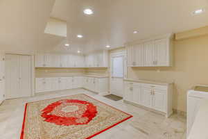 Kitchen featuring light countertops, white cabinets, and recessed lighting