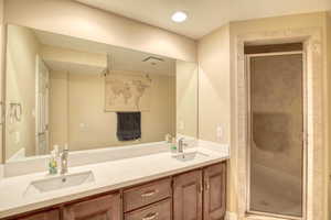 Bathroom with double vanity and a stall shower