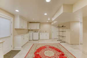 Kitchen with separate washer and dryer, white cabinets, recessed lighting, and light countertops